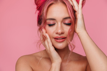 Portrait of alluring shirtless young woman touching her head with eyes closed