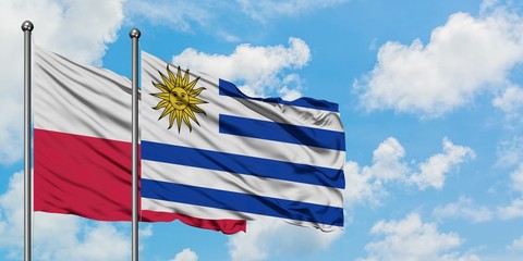 Poland and Uruguay flag waving in the wind against white cloudy blue sky together. Diplomacy concept, international relations.