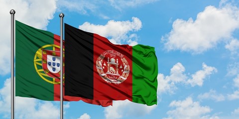 Portugal and Afghanistan flag waving in the wind against white cloudy blue sky together. Diplomacy...