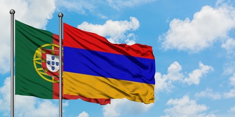 Portugal and Armenia flag waving in the wind against white cloudy blue sky together. Diplomacy concept, international relations.