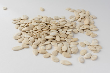 Roasted pumpkin seeds with salt on white background.