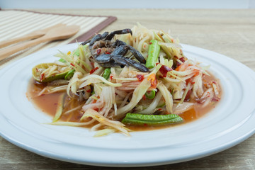 Green Papaya Salad (Som tum) is spicy on wood table
