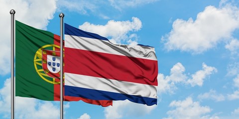 Portugal and Costa Rica flag waving in the wind against white cloudy blue sky together. Diplomacy concept, international relations.