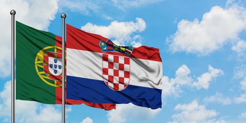 Portugal and Croatia flag waving in the wind against white cloudy blue sky together. Diplomacy...