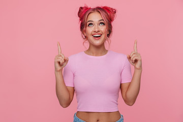 Portrait of young woman smiling and pointing finger upward at copyspace