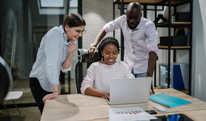 Obraz premium Positive male and female friendly colleagues enjoying work break togetherness watching funny comedy show in office building connected to free wifi on laptop device, concept of entrepreneurship