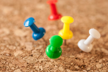 Various сolors of push pins on cork board