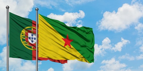 Portugal and French Guiana flag waving in the wind against white cloudy blue sky together. Diplomacy concept, international relations.