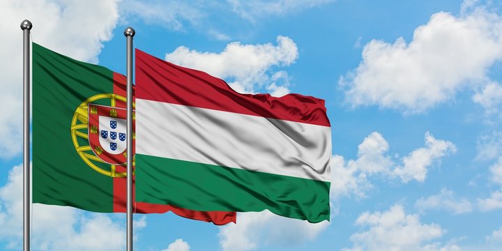 Portugal and Hungary flag waving in the wind against white cloudy blue sky together. Diplomacy concept, international relations.