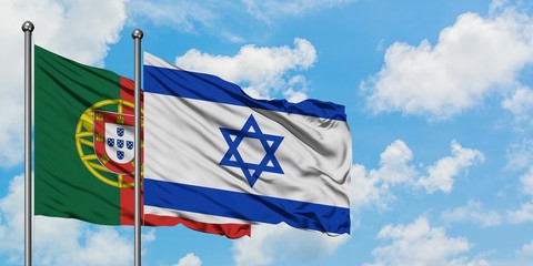 Portugal and Israel flag waving in the wind against white cloudy blue sky together. Diplomacy concept, international relations.