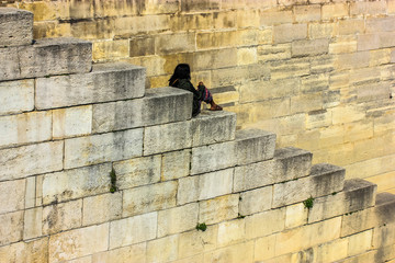 Lonely girl sits on the steps, India