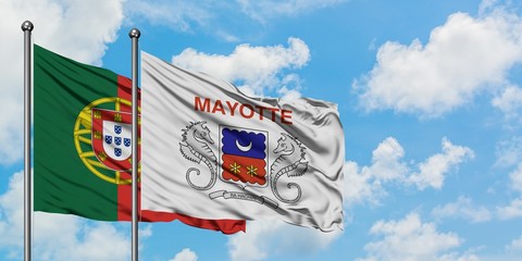Portugal and Mayotte flag waving in the wind against white cloudy blue sky together. Diplomacy concept, international relations.