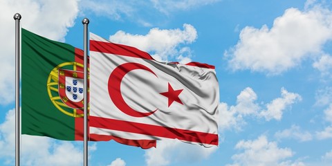 Portugal and Northern Cyprus flag waving in the wind against white cloudy blue sky together....
