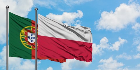 Portugal and Poland flag waving in the wind against white cloudy blue sky together. Diplomacy concept, international relations.