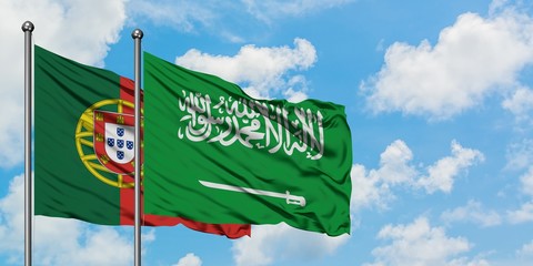 Portugal and Saudi Arabia flag waving in the wind against white cloudy blue sky together. Diplomacy...