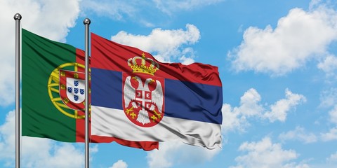 Portugal and Serbia flag waving in the wind against white cloudy blue sky together. Diplomacy concept, international relations.