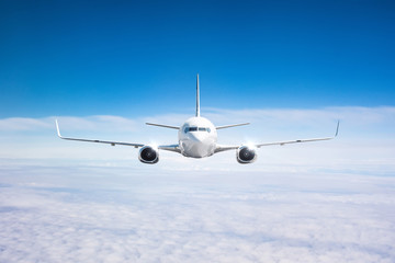 Fototapeta na wymiar Airplane in the sky above the cloudscape flight journey trip, view straight.