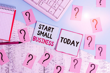 Conceptual hand writing showing Start Small Business. Concept meaning Aspiring Entrepreneur a New Venture Trade Industry Writing tools and scribbled paper on top of the wooden table