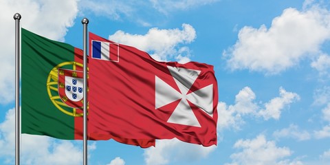 Portugal and Wallis And Futuna flag waving in the wind against white cloudy blue sky together....