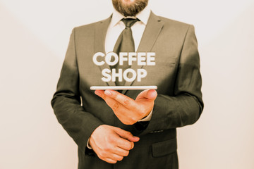 Word writing text Coffee Shop. Business photo showcasing small informal restaurant serving coffee and light refreshments Male human wear formal work suit hold smart hi tech smartphone use one hand