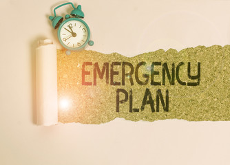 Text sign showing Emergency Plan. Business photo showcasing procedures for handling sudden or unexpected situations Alarm clock and torn cardboard placed above a wooden classic table backdrop