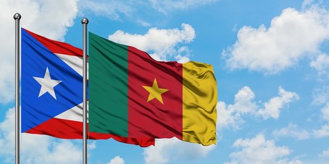 Puerto Rico and Cameroon flag waving in the wind against white cloudy blue sky together. Diplomacy concept, international relations.