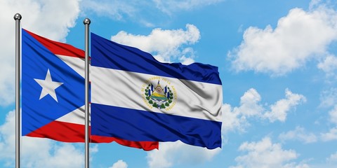 Puerto Rico and El Salvador flag waving in the wind against white cloudy blue sky together. Diplomacy concept, international relations.