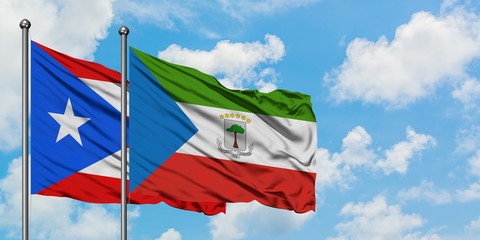 Puerto Rico and Equatorial Guinea flag waving in the wind against white cloudy blue sky together. Diplomacy concept, international relations.