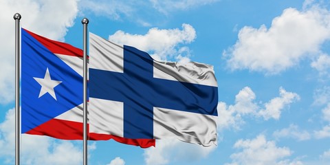 Puerto Rico and Finland flag waving in the wind against white cloudy blue sky together. Diplomacy...