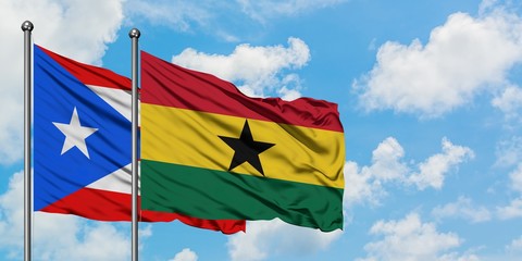 Puerto Rico and Ghana flag waving in the wind against white cloudy blue sky together. Diplomacy...