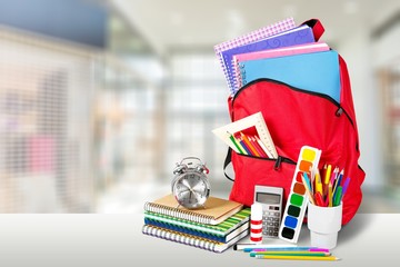 School Backpack with stationery on wooden table