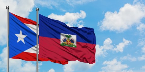 Puerto Rico and Haiti flag waving in the wind against white cloudy blue sky together. Diplomacy concept, international relations.