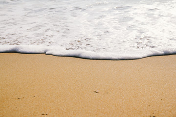 Ocean wave on sandy beach background