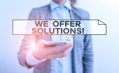Handwriting text We Offer Solutions. Conceptual photo way to solve problem or deal with difficult situation Business concept with mobile phone and business woman