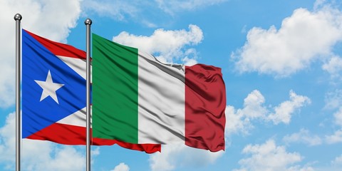 Puerto Rico and Italy flag waving in the wind against white cloudy blue sky together. Diplomacy concept, international relations.