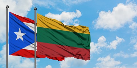 Puerto Rico and Lithuania flag waving in the wind against white cloudy blue sky together. Diplomacy concept, international relations.