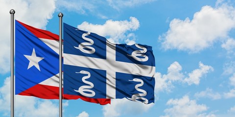 Puerto Rico and Martinique flag waving in the wind against white cloudy blue sky together....