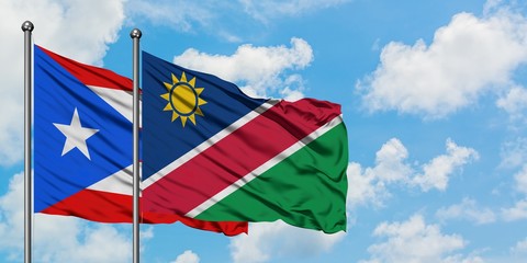 Puerto Rico and Namibia flag waving in the wind against white cloudy blue sky together. Diplomacy concept, international relations.