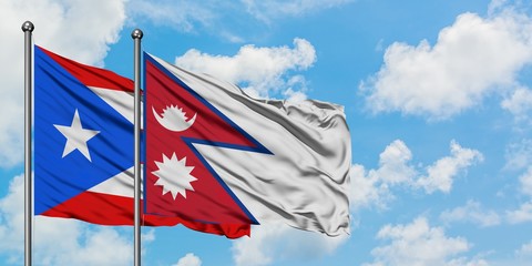 Puerto Rico and Nepal flag waving in the wind against white cloudy blue sky together. Diplomacy concept, international relations.