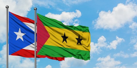 Puerto Rico and Sao Tome And Principe flag waving in the wind against white cloudy blue sky...