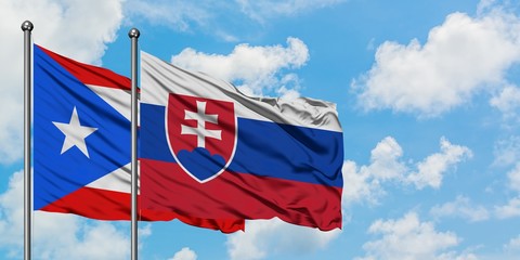 Puerto Rico and Slovakia flag waving in the wind against white cloudy blue sky together. Diplomacy concept, international relations.