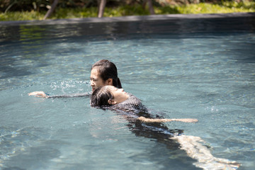 Life guard woman holding sinking child swimming in water,female lifesaver help girl in summer ,first aid for drowning tourist or asian mother rescuing unconscious daughter drowning in swimming pool