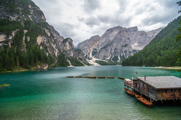 Lake Lago di Braies in Dolomiti mountains, South Tyrol, Italy. Dock with romantic old wooden rowing boats on lake. Amazing view of Lago di Braies.