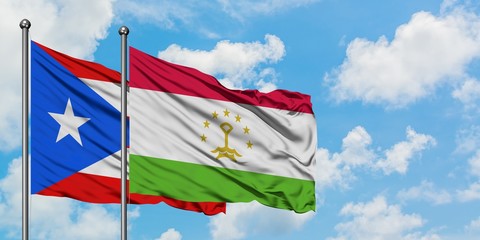 Puerto Rico and Tajikistan flag waving in the wind against white cloudy blue sky together. Diplomacy concept, international relations.