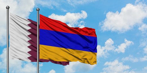 Qatar and Armenia flag waving in the wind against white cloudy blue sky together. Diplomacy...