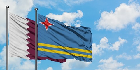 Qatar and Aruba flag waving in the wind against white cloudy blue sky together. Diplomacy concept,...