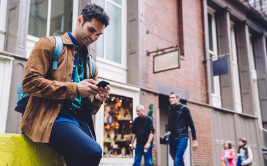 Happy man using smartphone on urban background