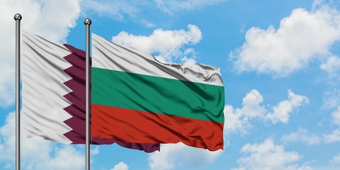 Qatar and Bulgaria flag waving in the wind against white cloudy blue sky together. Diplomacy...