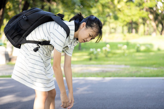 Stress asian child girl carrying heavy school bag or backpack, female teenage feeling pain on back, full of books on her back, going to school for the first time, tired student back to school learning