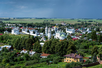 Fototapeta na wymiar Russia, Vladimir Oblast, Golden Ring, Suzdal: Arial view of one of the oldest Russian towns with famous old Alexandrovsky Convent and river Kamenka seen from bell tower of Rizopolozhenskiy Monastery.